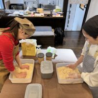 古民家福寿舎での味噌作りレッスンにて、楽しそうに麹を混ぜて仕込みを行う2人の参加者