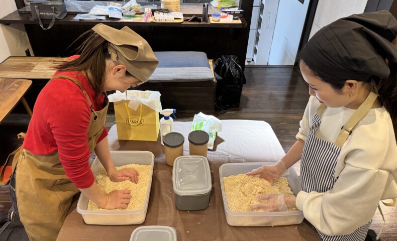 古民家福寿舎での味噌作りレッスンにて、楽しそうに麹を混ぜて仕込みを行う2人の参加者